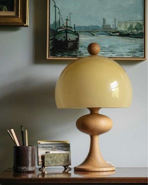 Vintage oak lamp with a yellow glass shade under a harbour painting