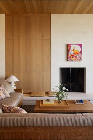 Living room with oak panelling, a plaster fireplace and a colourful abstract painting